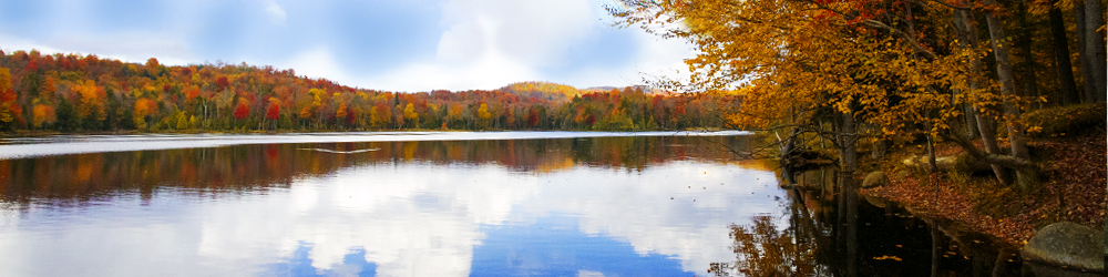 Pictured is one of the lakes in Old Forge during the fall. The red and orange colors from the trees are being reflected in the water. One of the many beautiful fall scenes during the fall season.