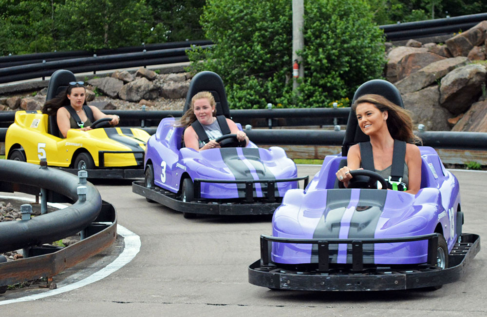 Three girls enjoying a ride on the all new go-karts at Calypso's Cove.