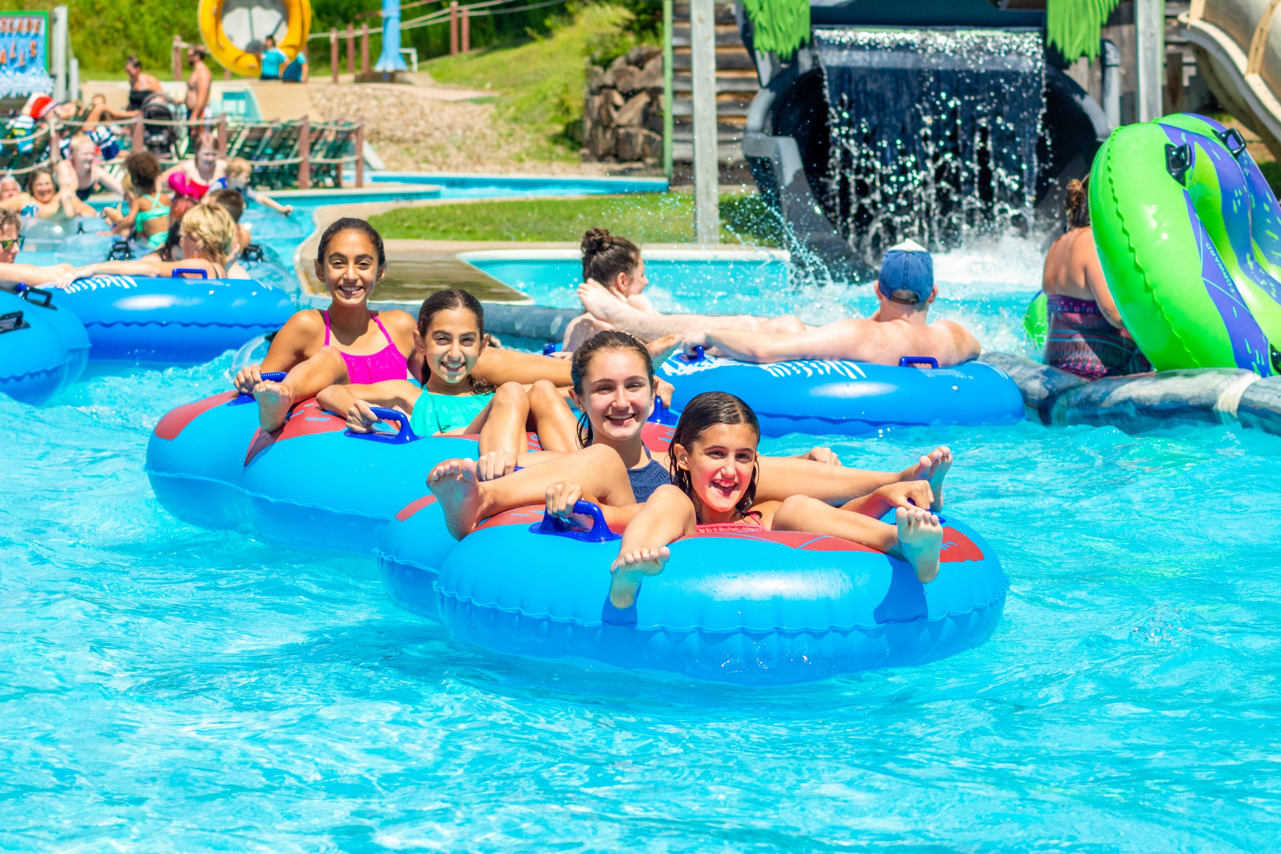 people in double tubs floating and smiling on the log jammer